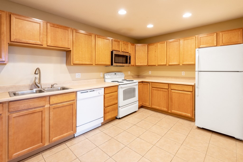 a kitchen with white appliances and wooden cabinets