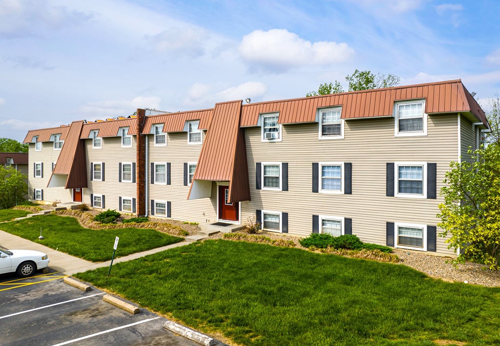 a large apartment building with a red metal roof