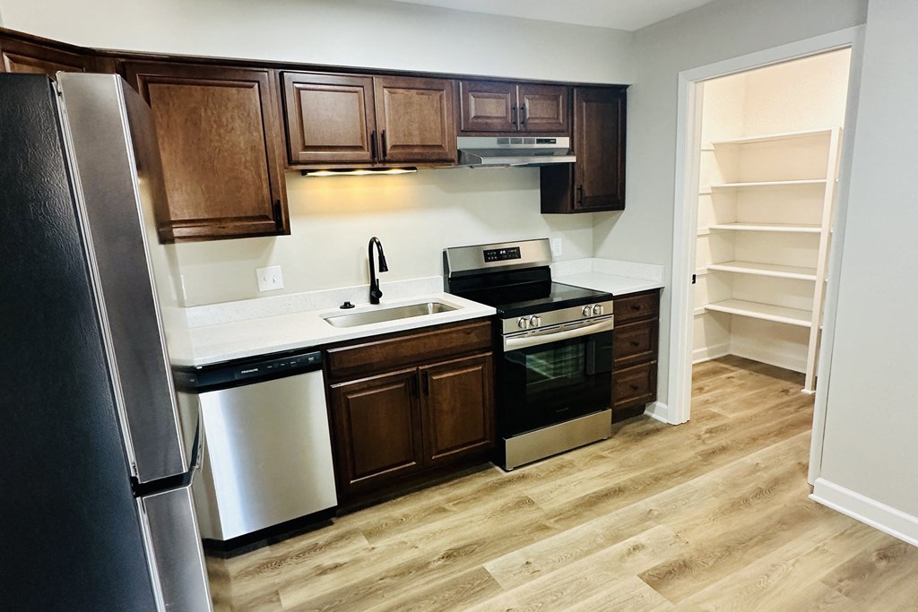 a kitchen with wooden cabinets and stainless steel appliances