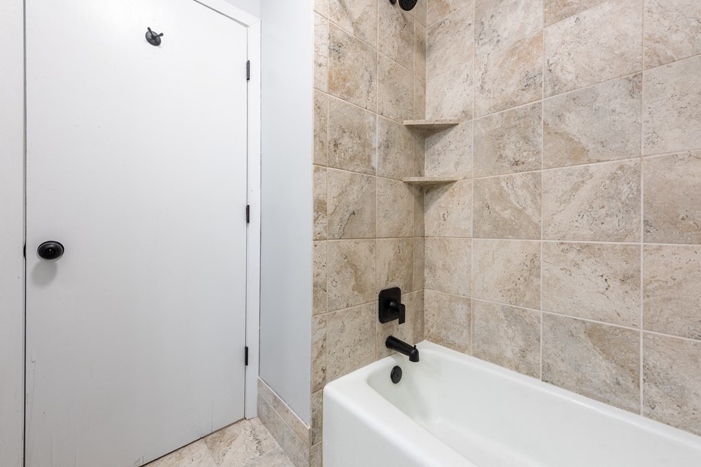 a bathroom with a white bathtub and a white door