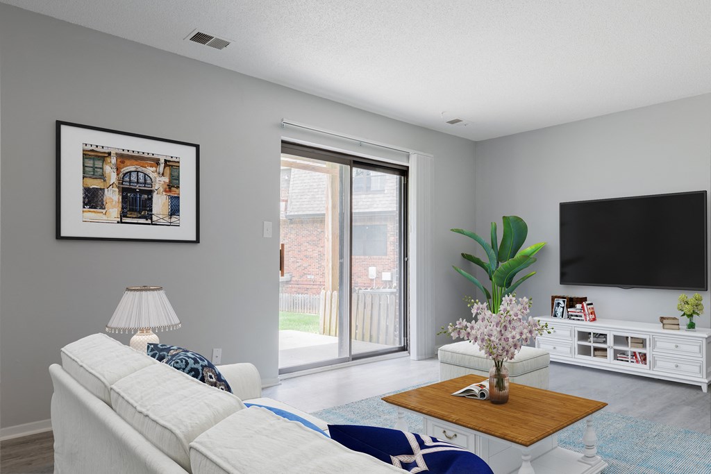 a living room with a sliding glass door and a tv on the wall