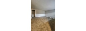 A room with a carpeted floor and a door.