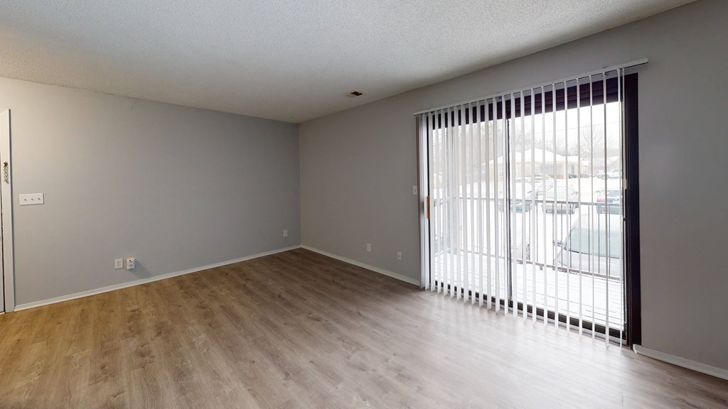 a bedroom with a sliding glass door and hardwood floors