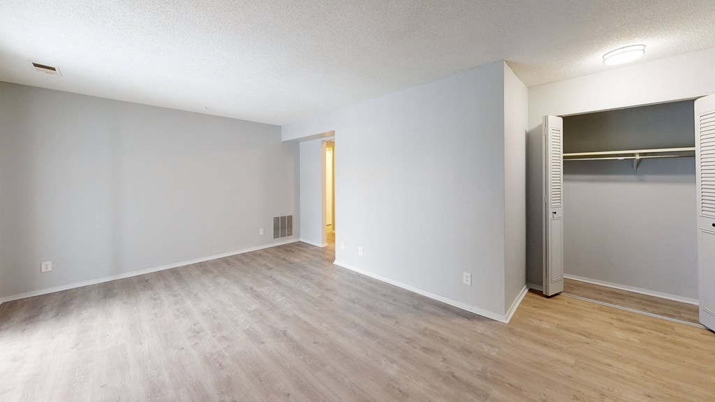 an empty bedroom with a closet and an open door