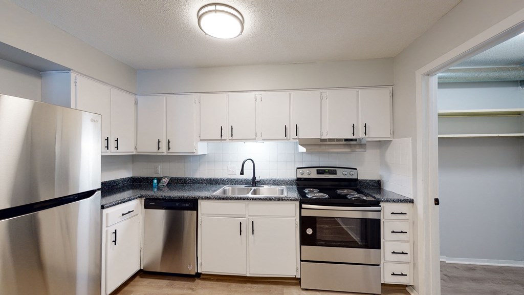 a kitchen with white cabinets and stainless steel appliances