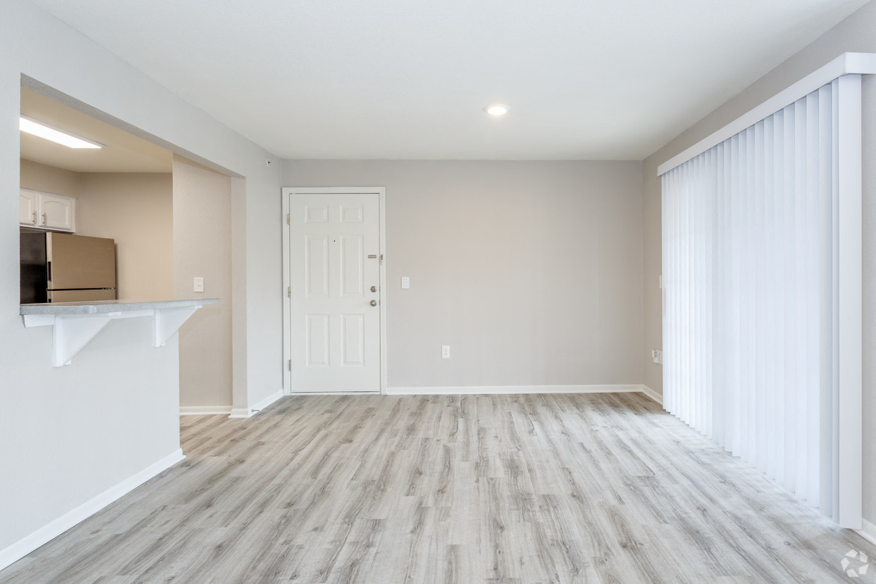 Living room with vinyl plank flooring with breakfast bar and patio