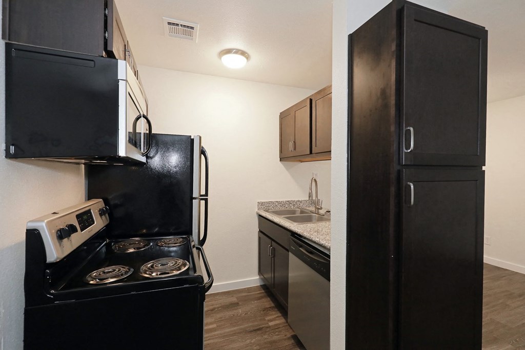 a kitchen with black cabinets and stainless steel appliances at Bennett Ridge Apartments, Oklahoma City, OK, 73132