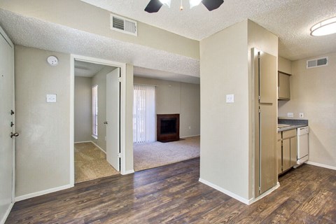 an empty living room and kitchen with a fireplace