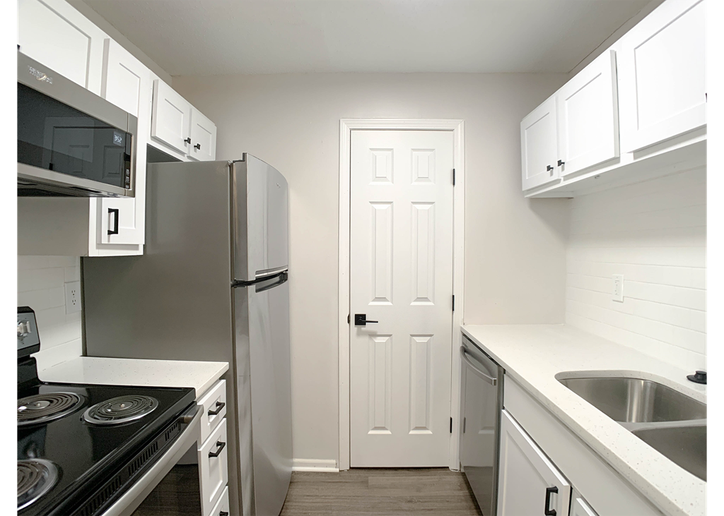 Photo of kitchen with white cabinetry and stainless steel appliances.