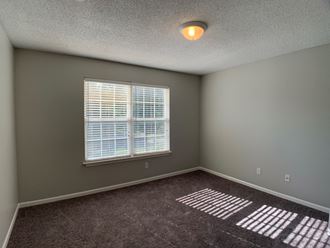 Large carpeted bedroom with window