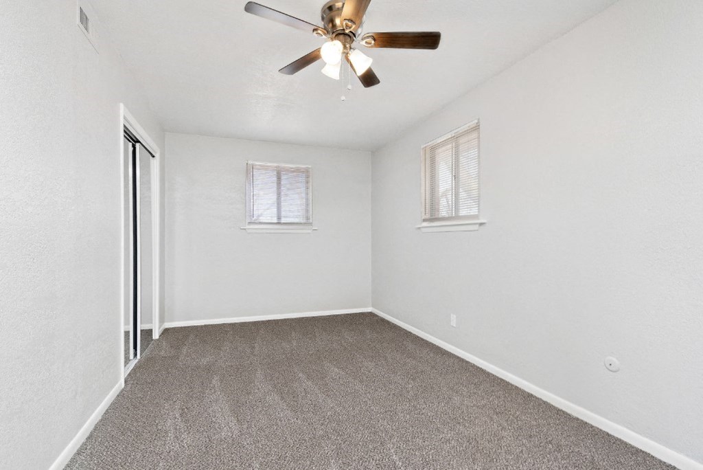 large carpeted room with ceiling fan