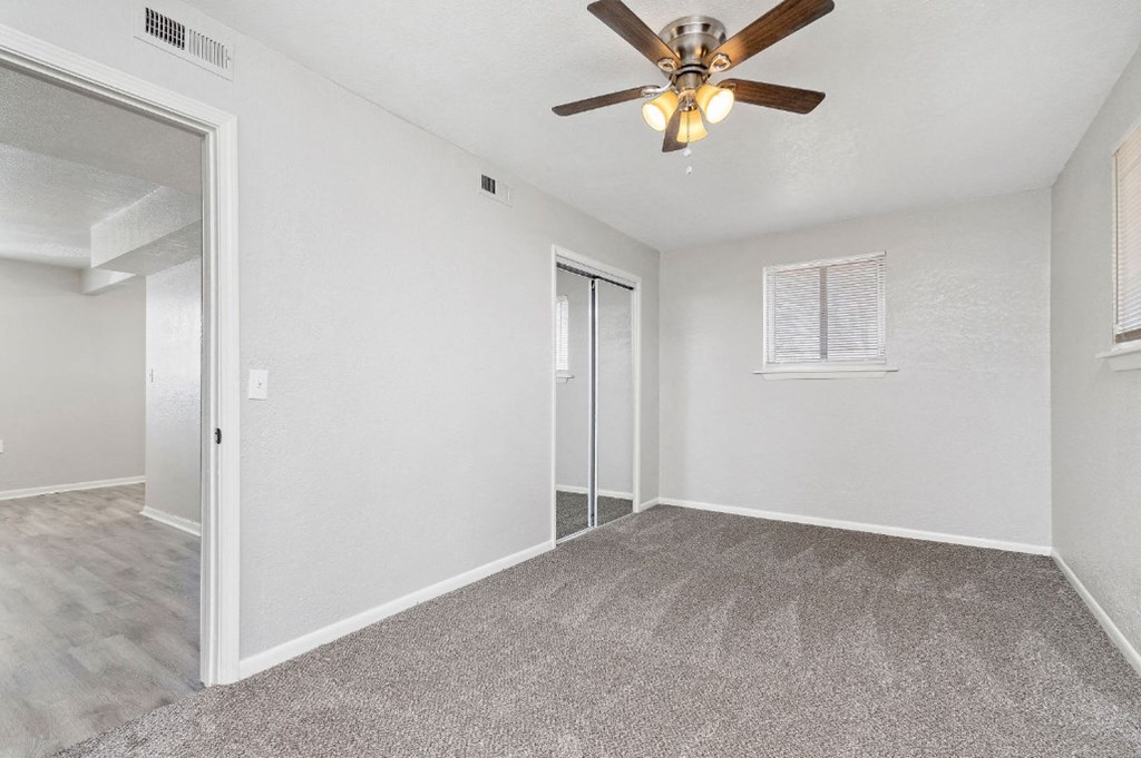 large carpeted room with ceiling fan