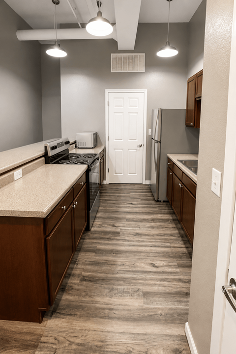 A kitchen with wooden floors and white walls.