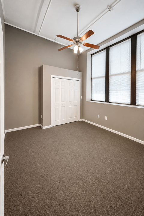 A room with a ceiling fan and a white door.