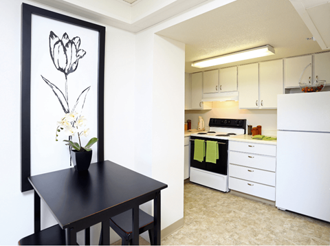 a kitchen with white cabinets and a black table