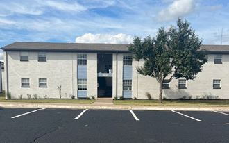 a white building with a tree in front of it