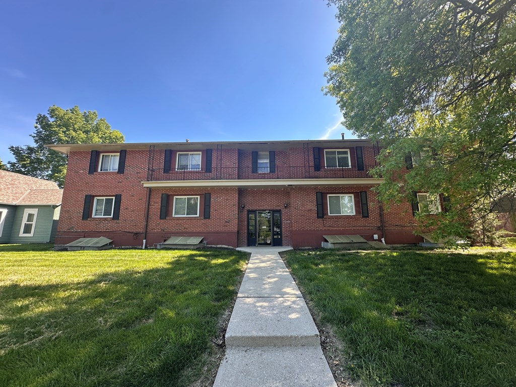 A red brick building with a black door and windows.