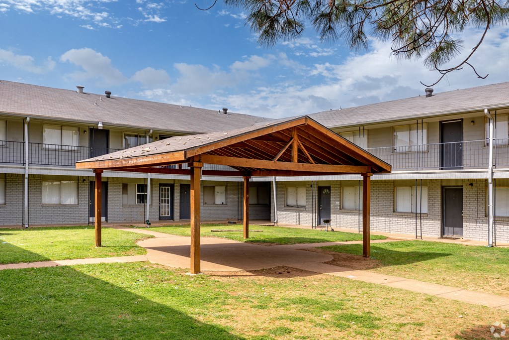 a building with a wooden pavilion in the courtyard