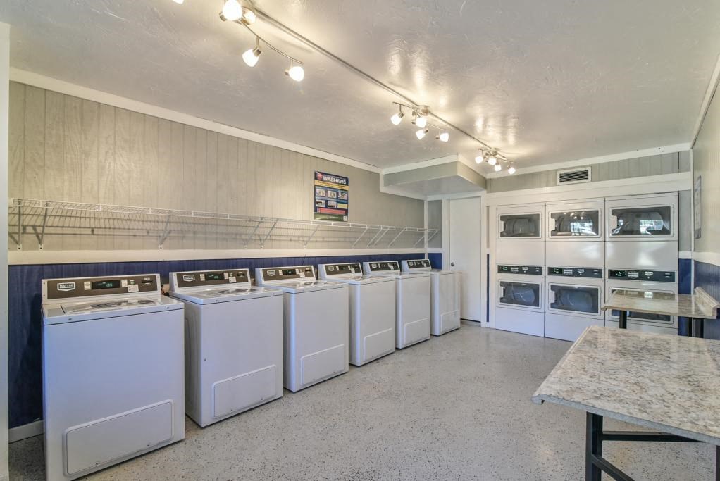 a laundry room with lots of washes and dryers