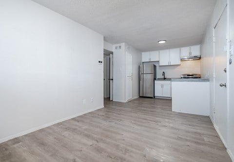 an empty apartment with white walls and a kitchen
