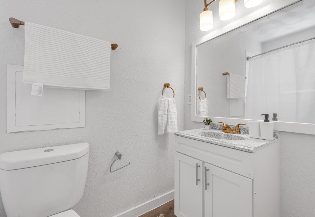 a white bathroom with a toilet and a sink