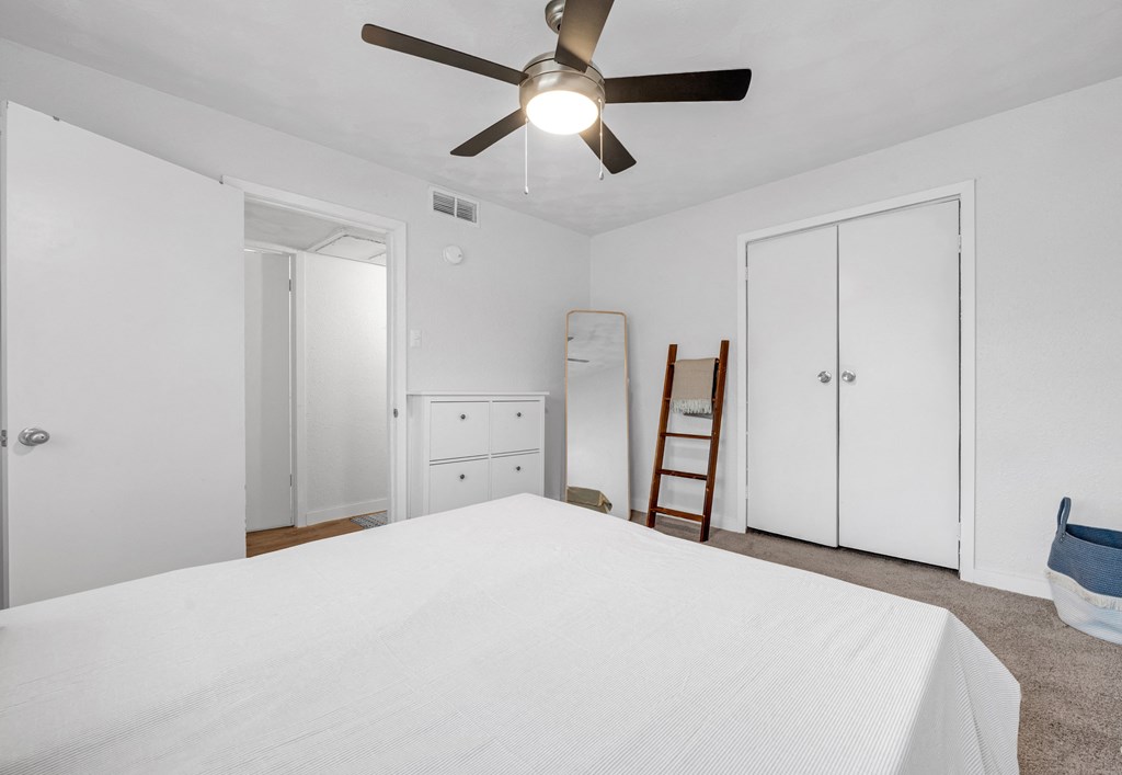 a bedroom with a large bed and a ceiling fan