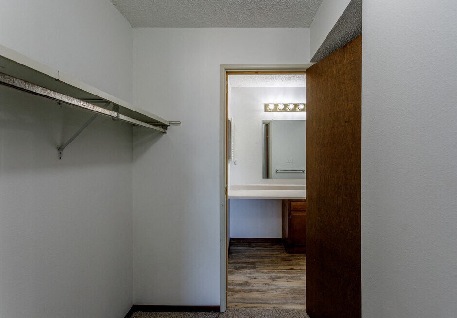 an empty room with a walk in closet and a mirror