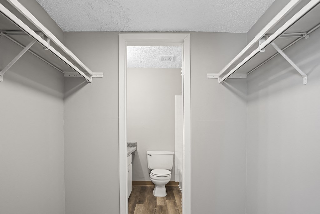 the interior of a bathroom with a toilet and a closet