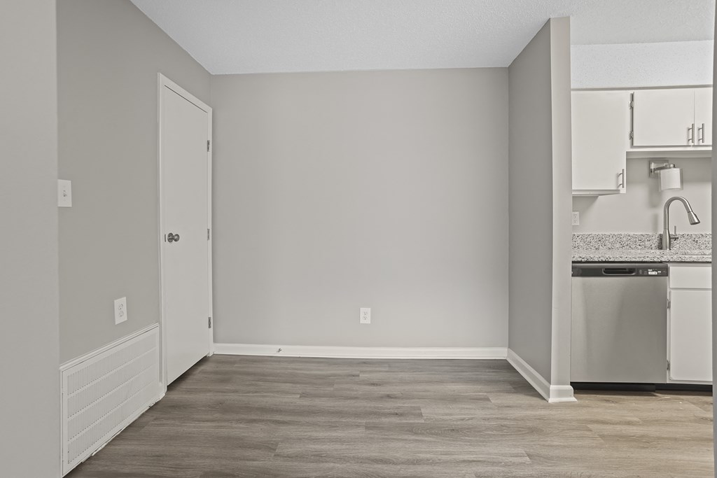 an empty room with a kitchen and a sink and a refrigerator