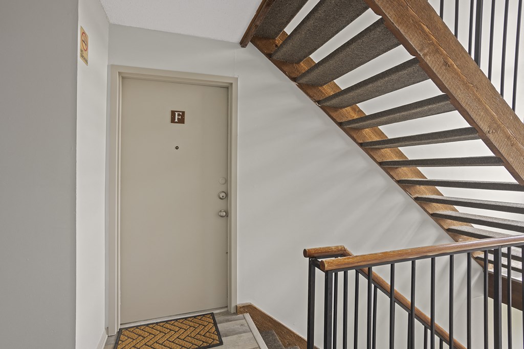 a staircase in a home with a white door and a stairwell with a door