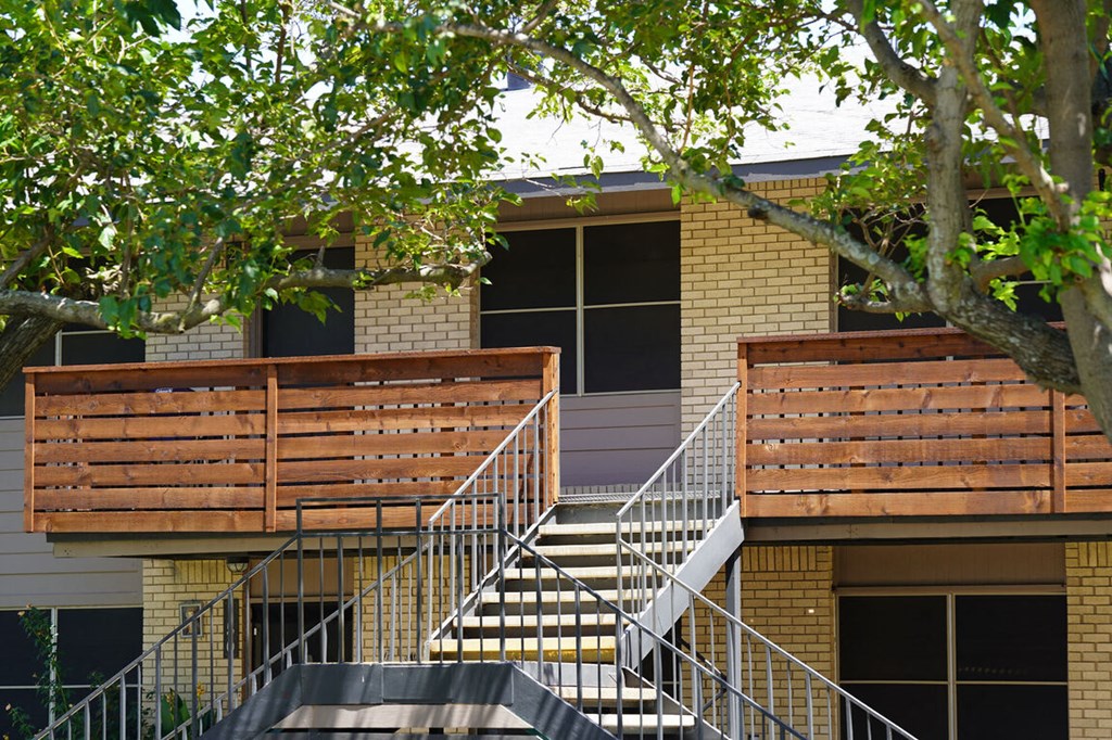 a building with stairs and a tree in front of it