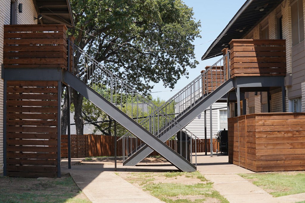 a steel bridge connects two buildings in a yard