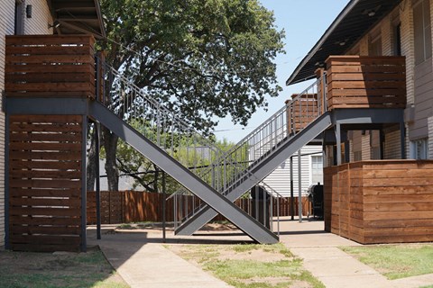 a steel bridge connects two buildings in a yard