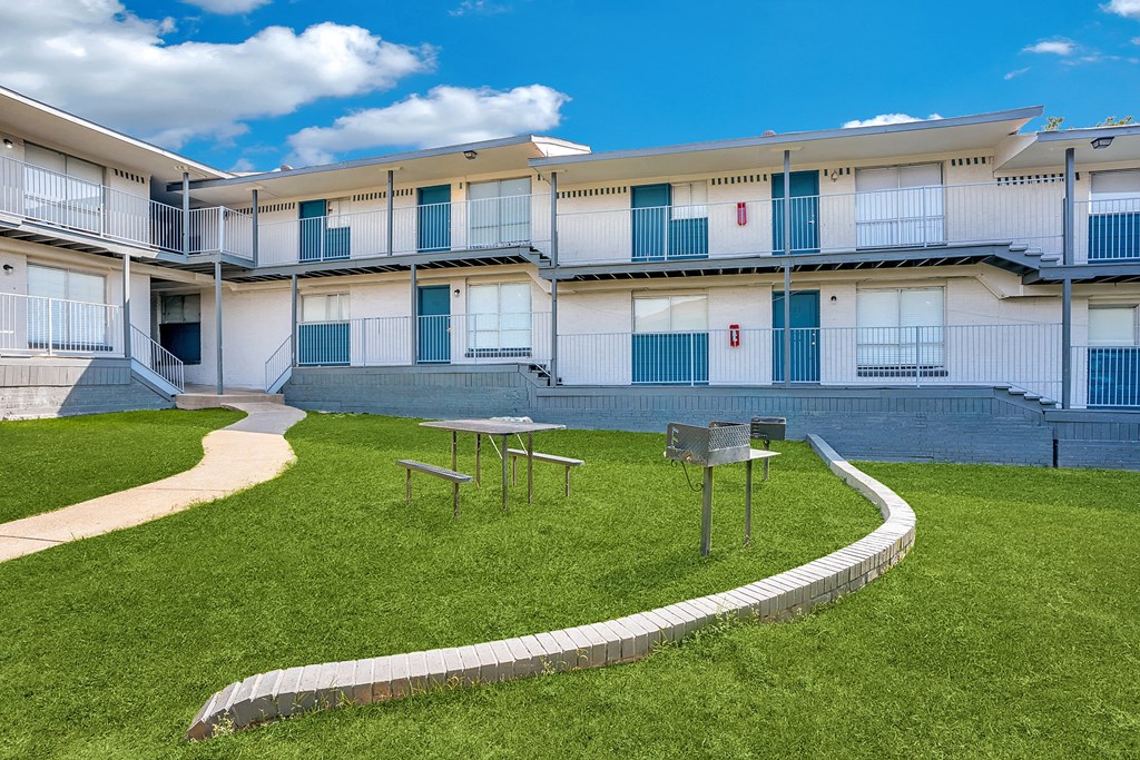 an apartment building with a courtyard with picnic tables