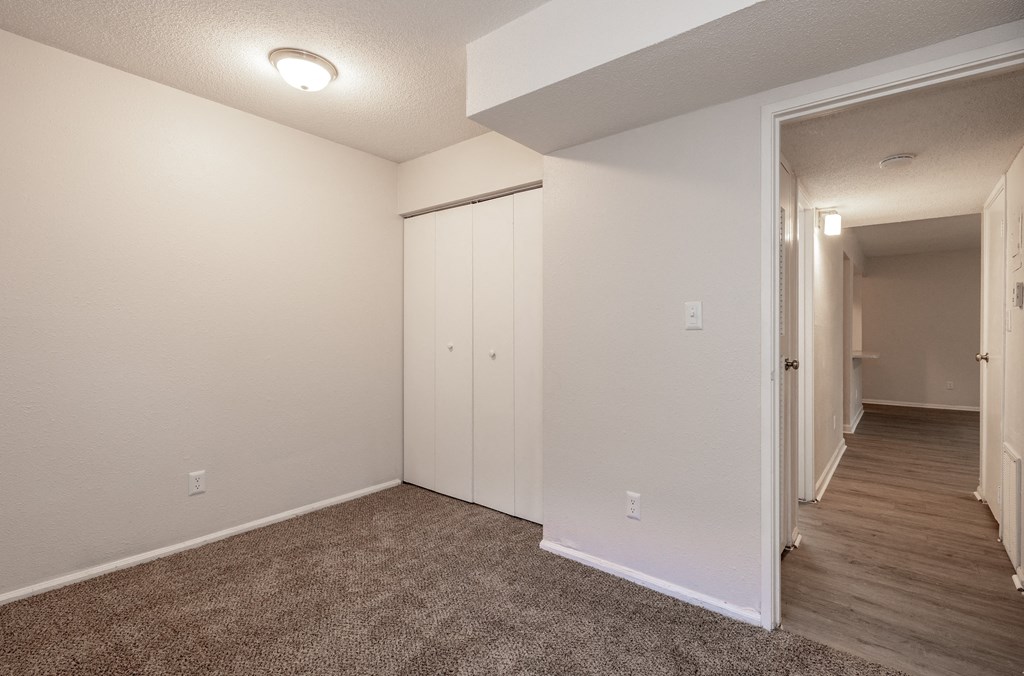 a bedroom with white walls and a carpeted floor