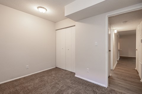a bedroom with white walls and a carpeted floor