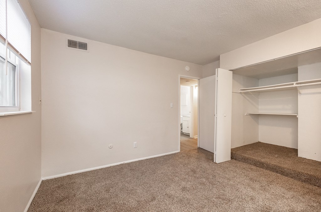 a bedroom with an open doorway and a carpeted floor