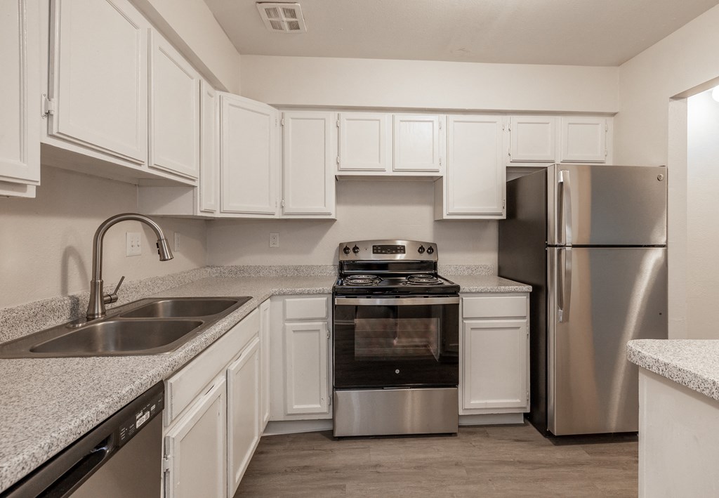 a kitchen with white cabinets and stainless steel appliances