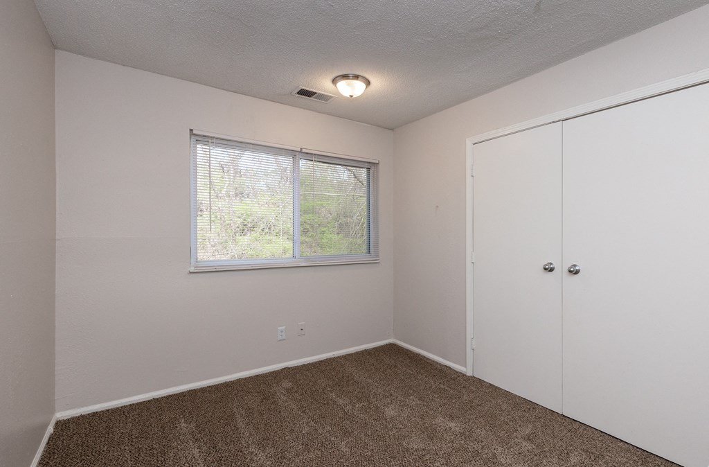 a bedroom with a window and a door