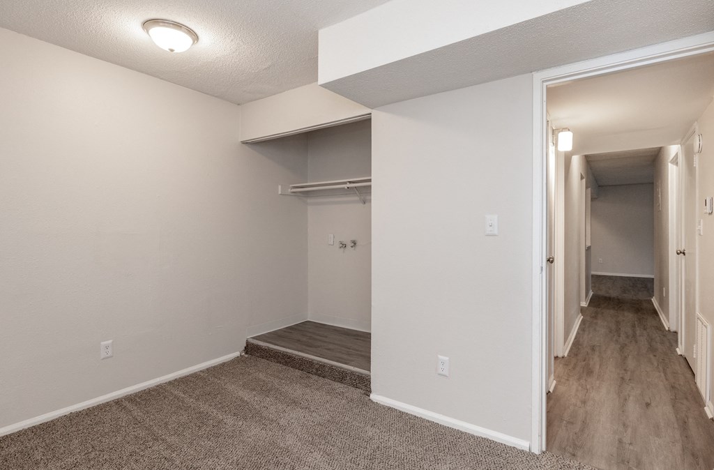 a bedroom with a medium sized walk in closet and a carpeted floor