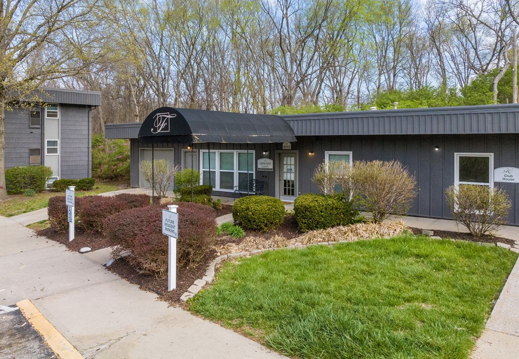 a building with a black awning and a white sign in front of it