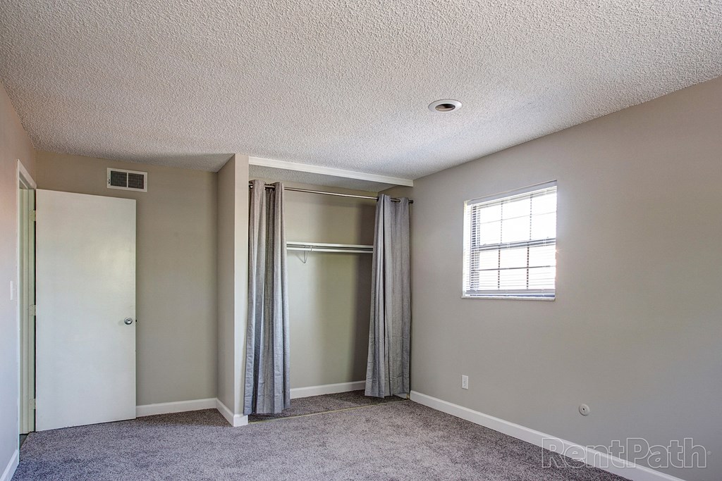 an empty room with a closet and a window