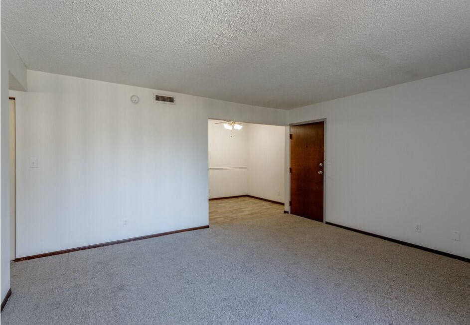 a bedroom with white walls and a carpeted floor