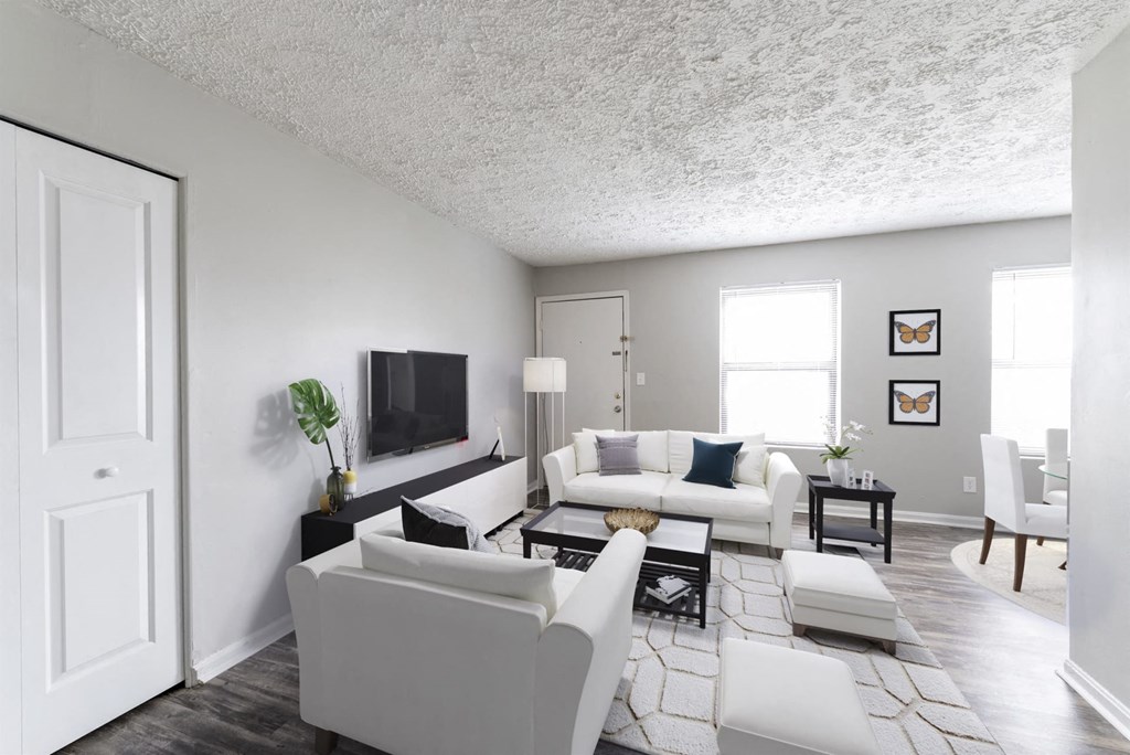 a living room with white furniture and a tv