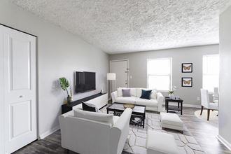 an open living room with white furniture and a tv