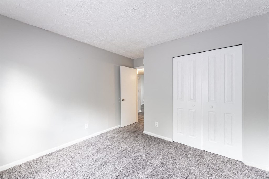 a bedroom with a closet and a door to a hallway