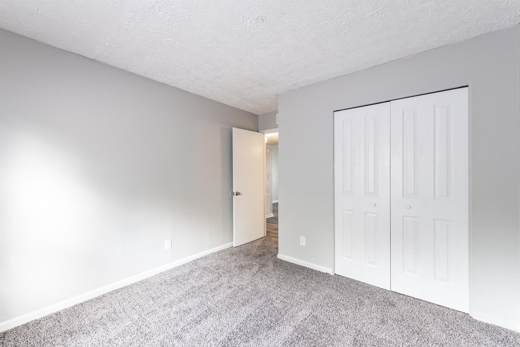 a bedroom with a closet and a door to a hallway
