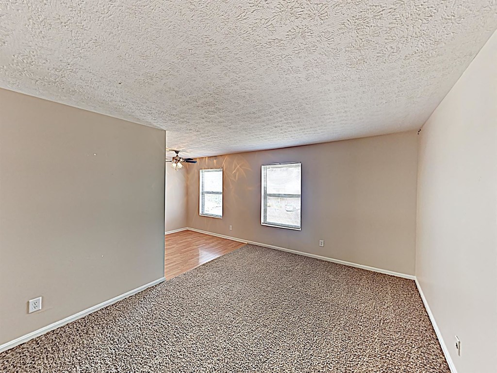 the living room and dining room of an empty house