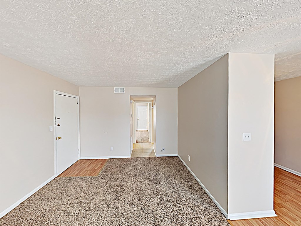 an empty living room with wood flooring and white walls