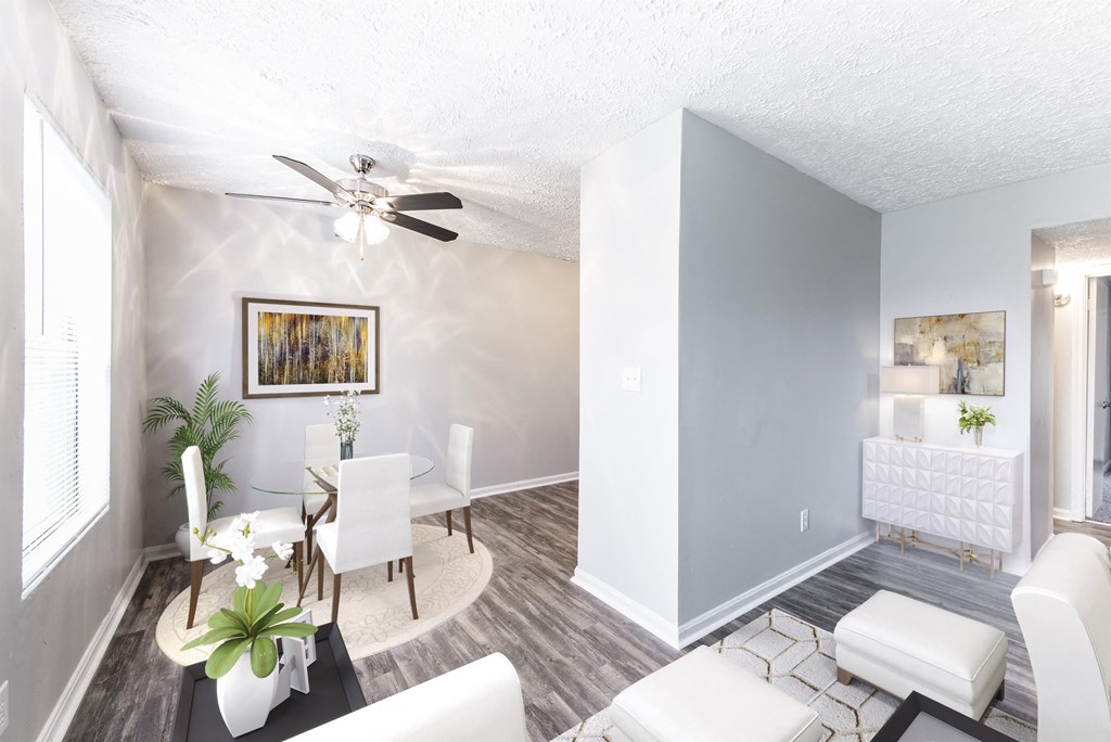 a living room and dining room with white furniture and a ceiling fan